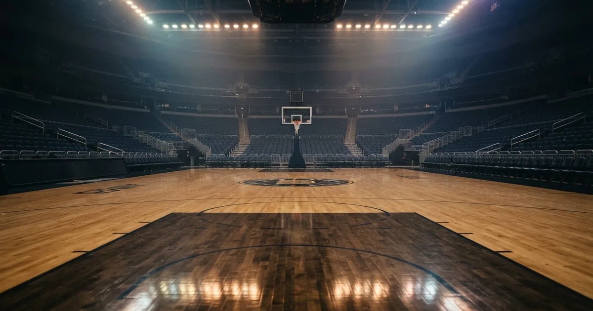 Eine leere Basketballhalle mit glänzendem Parkett und einem Korb im Hintergrund, Licht von Deckenstrahlern spiegelt sich im Boden.